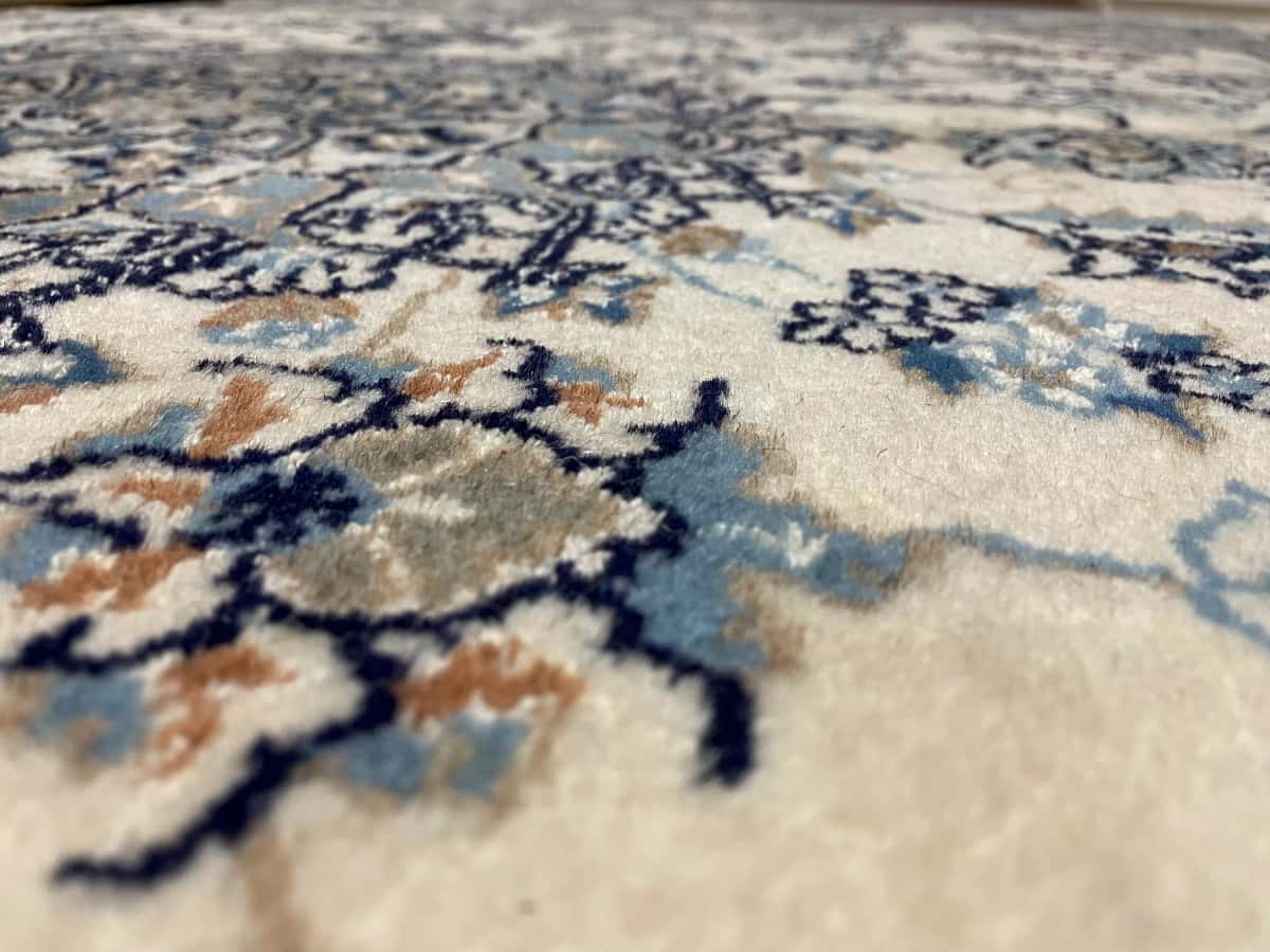 persischer Teppich im Nain Stil in den Maßen 212 Zentimeter Länge mal 194 Zentimeter Breite mit überwiegend beige und blau Farben — Nahaufnahme der Textur
