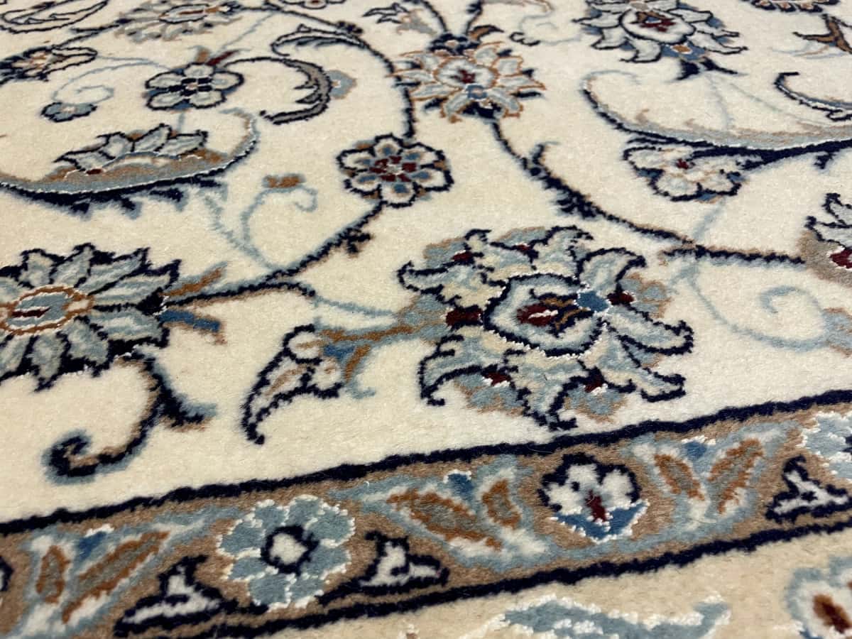 alfombra persa de estilo Nain en dimensiones 240 centímetros de largo por 162 centímetros de ancho con colores principalmente beige y azul — Primer plano de la textura