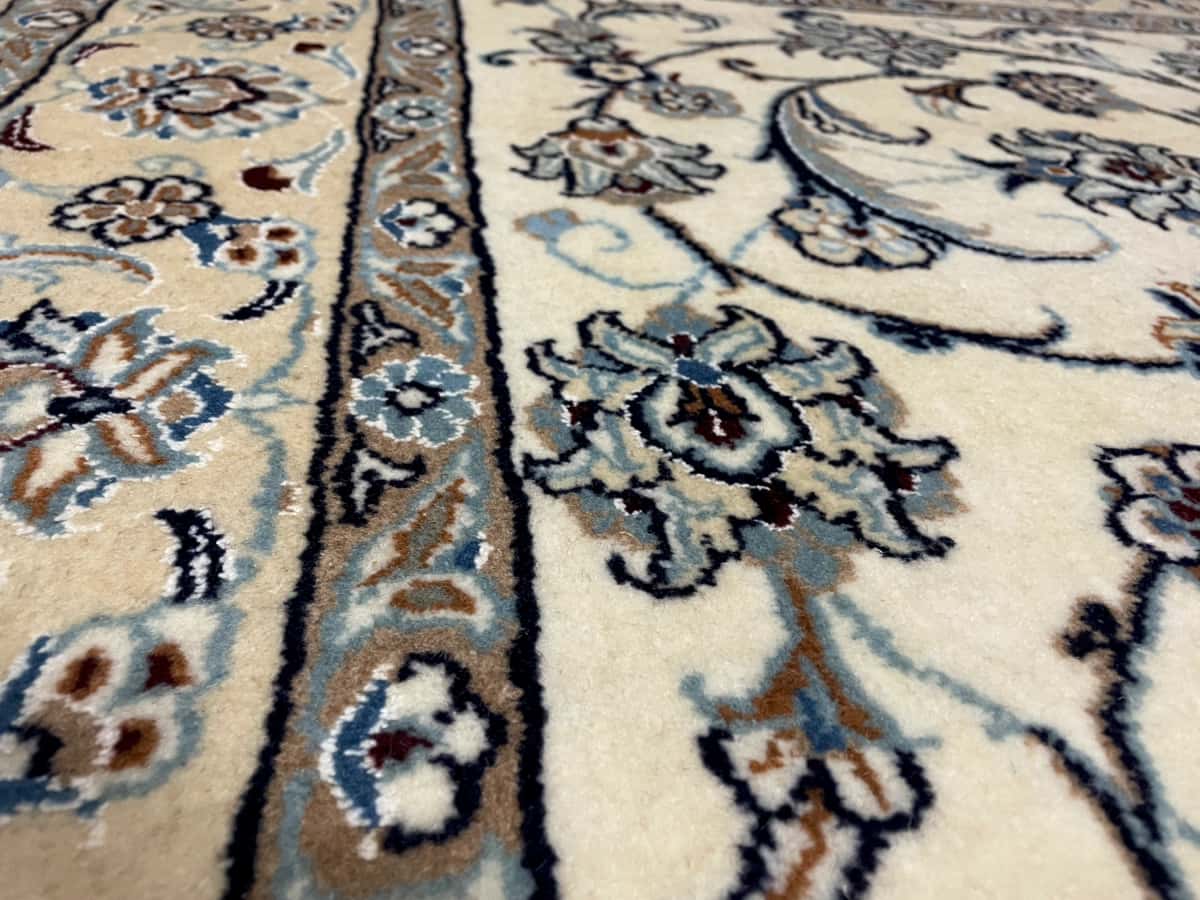 alfombra persa de estilo Nain en dimensiones 240 centímetros de largo por 162 centímetros de ancho con colores principalmente beige y azul — Primer plano de la textura