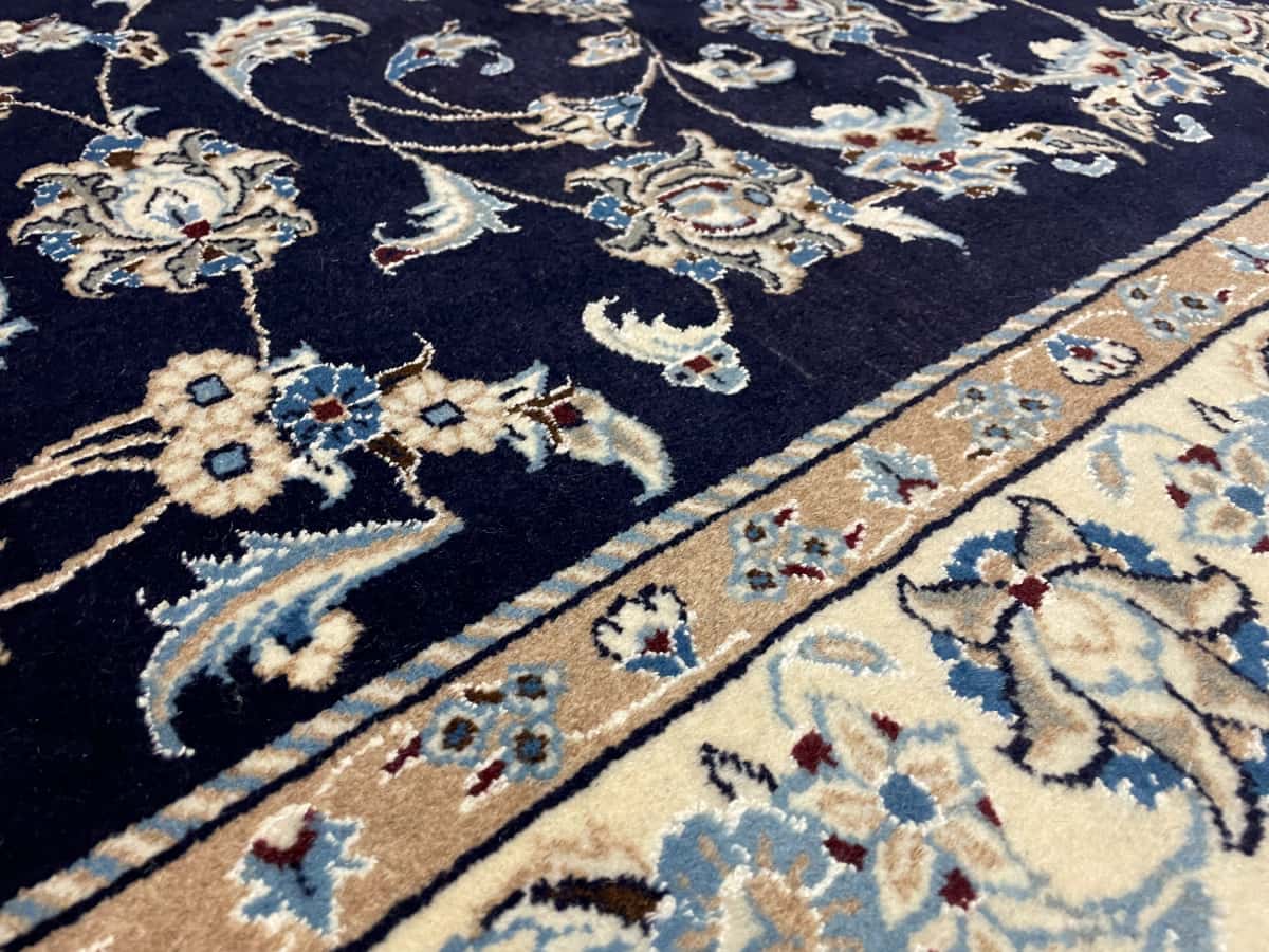 Persian rug of Nain style in dimensions 234 centimeters length by 168 centimeters width with mainly blue colors — Texture close-up