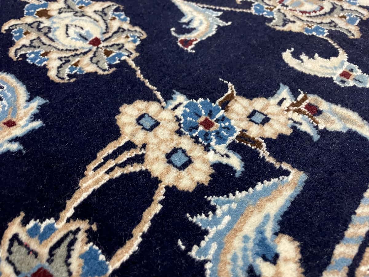 Persian rug of Nain style in dimensions 234 centimeters length by 168 centimeters width with mainly blue colors — Texture close-up