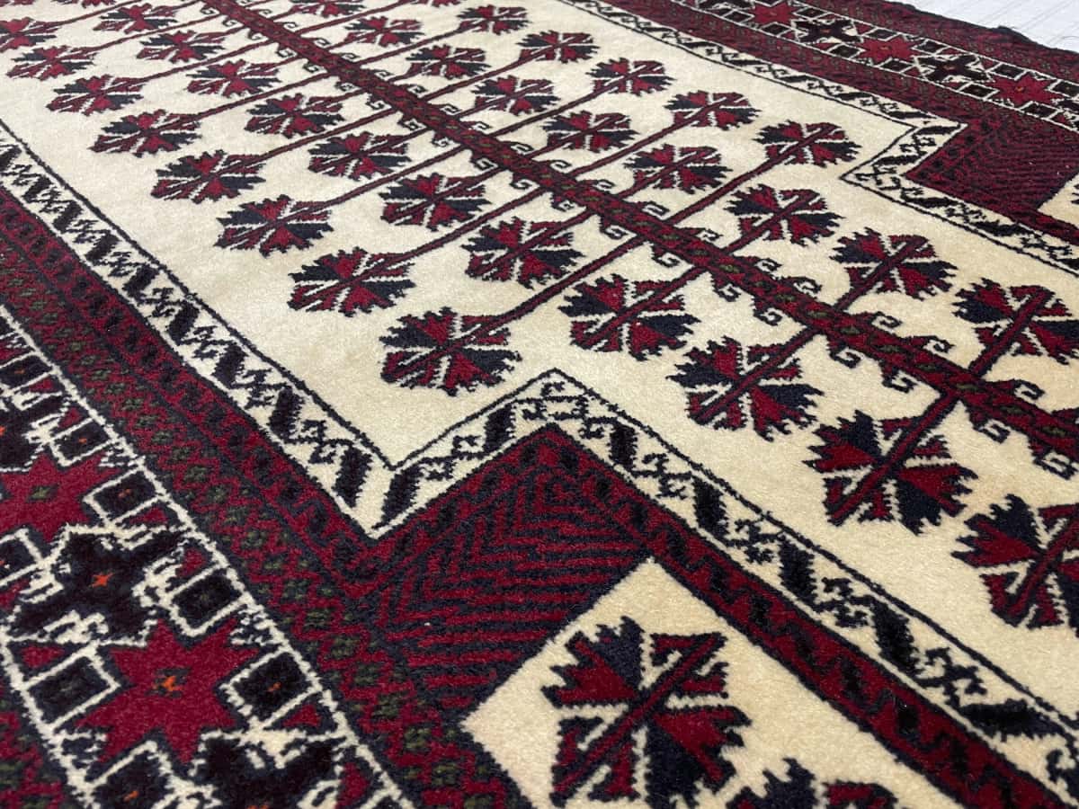 Persian rug of Turkoman style in dimensions 145 centimeters length by 101 centimeters width with mainly beige and red colors — Texture close-up