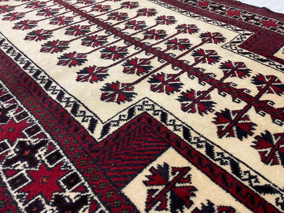persischer Teppich im turkmenischer Stil in den Maßen 145 Zentimeter Länge mal 101 Zentimeter Breite mit überwiegend beige und rot Farben — Nahaufnahme der Textur