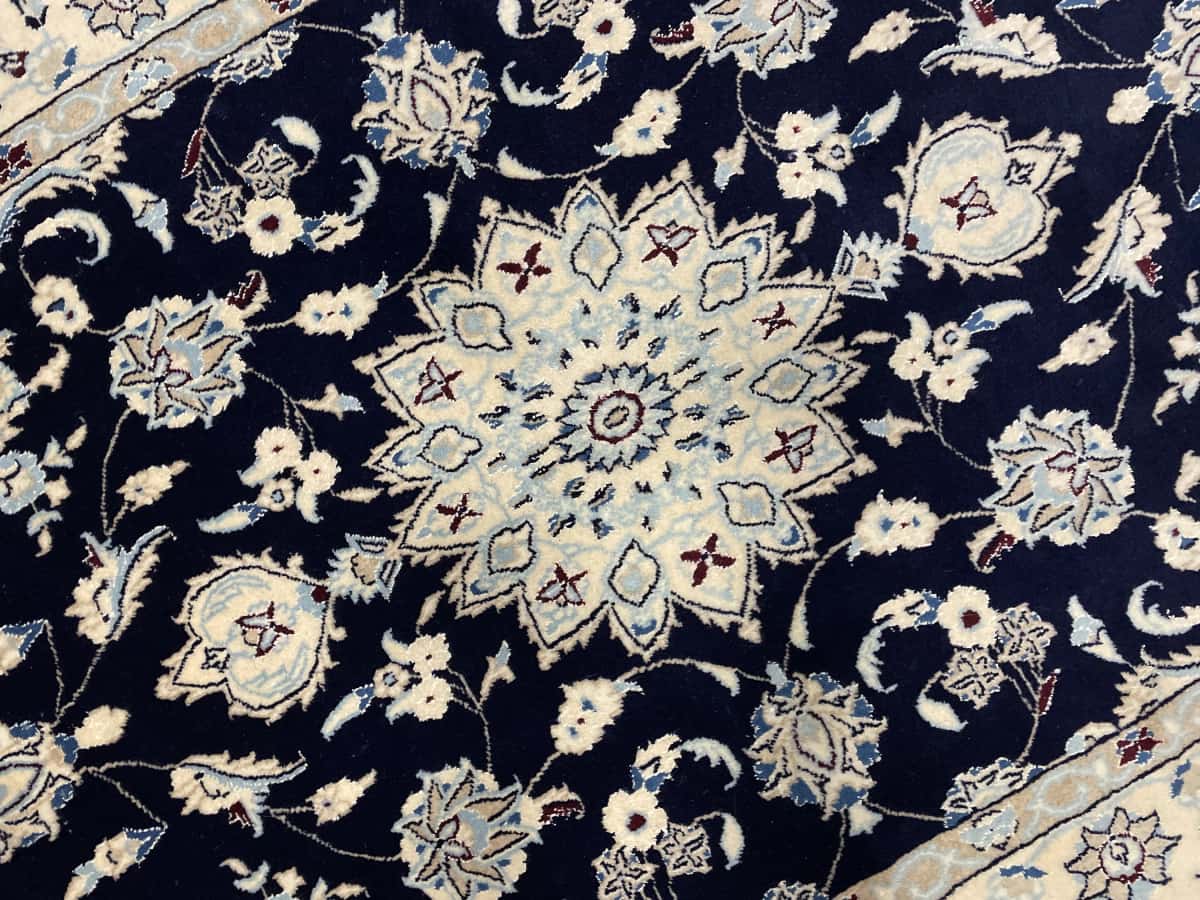 Persian rug of Nain style in dimensions 214 centimeters length by 148 centimeters width with mainly beige and blue colors — Texture close-up