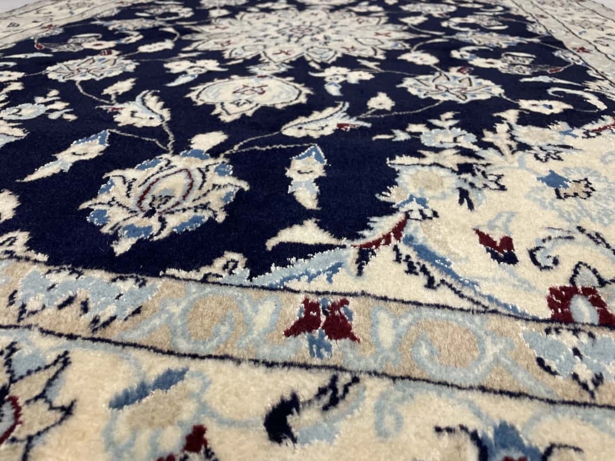 Persian rug of Nain style in dimensions 214 centimeters length by 148 centimeters width with mainly beige and blue colors — Texture close-up