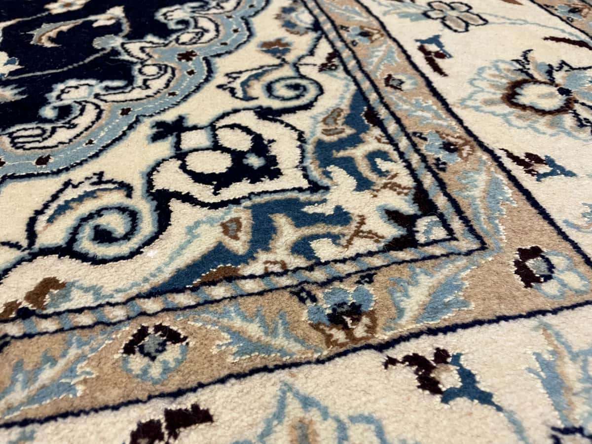 Persian rug of Nain style in dimensions 238 centimeters length by 160 centimeters width with mainly beige and blue colors — Texture close-up