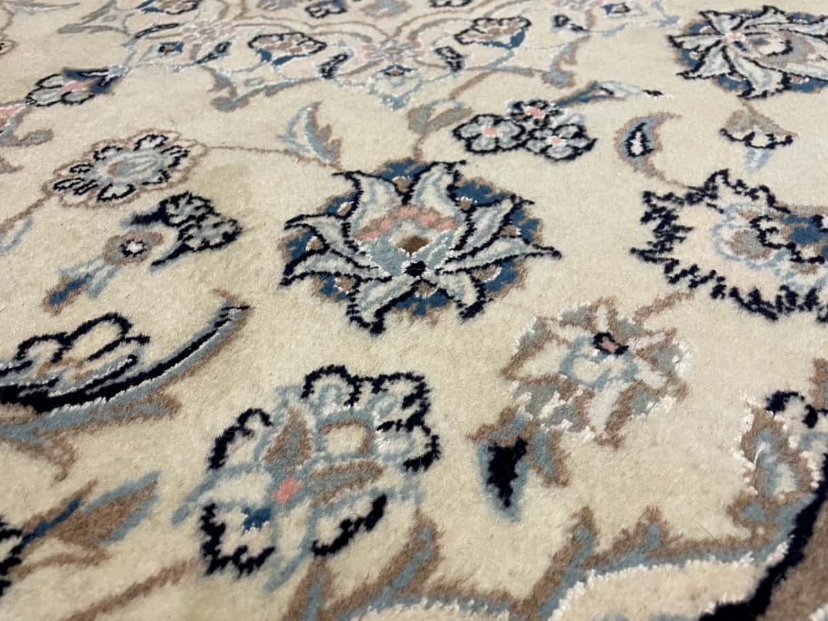 Persian rug of Nain style in dimensions 230 centimeters length by 162 centimeters width with mainly beige colors — Texture close-up