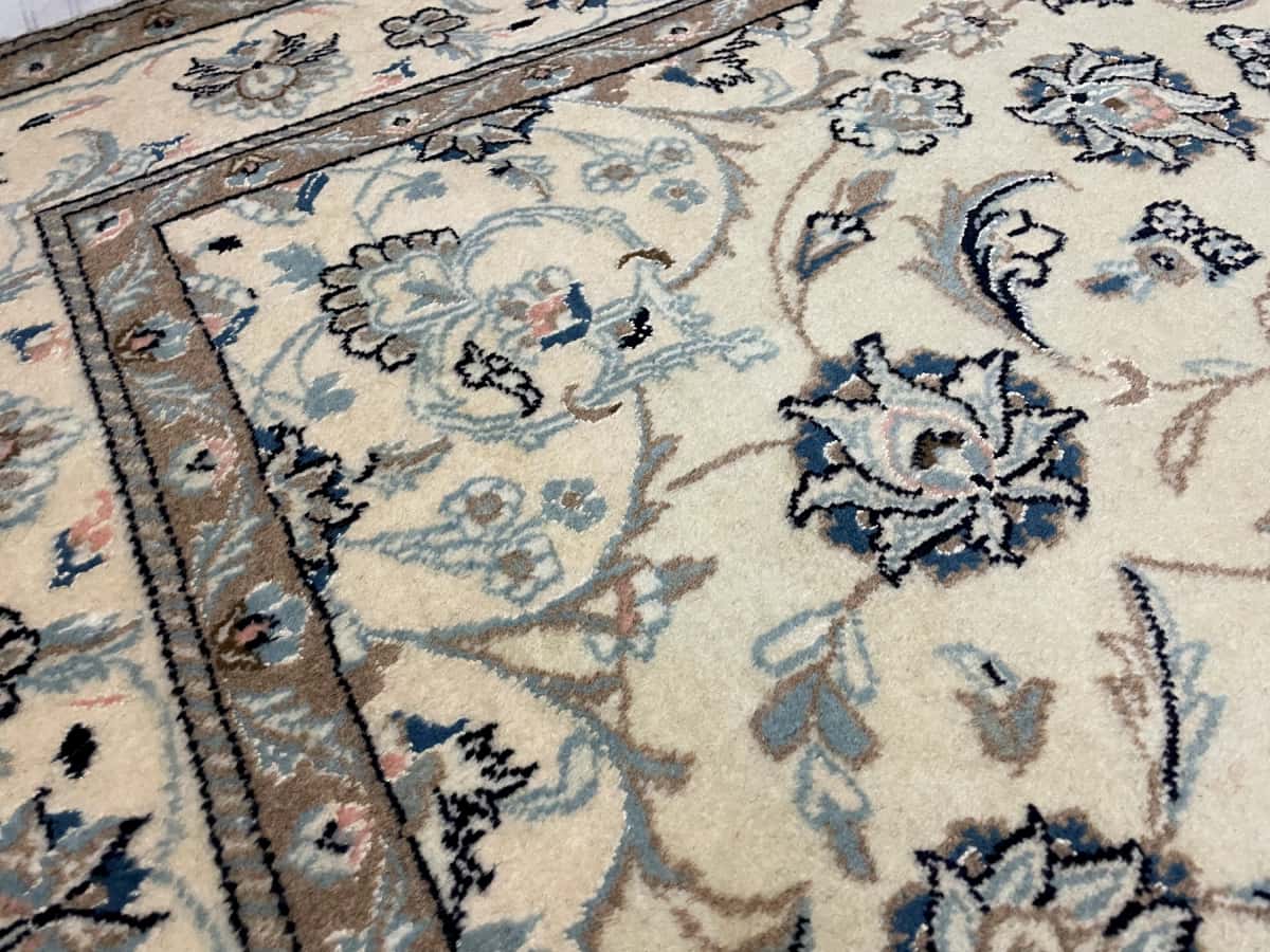Persian rug of Nain style in dimensions 230 centimeters length by 162 centimeters width with mainly beige colors — Texture close-up