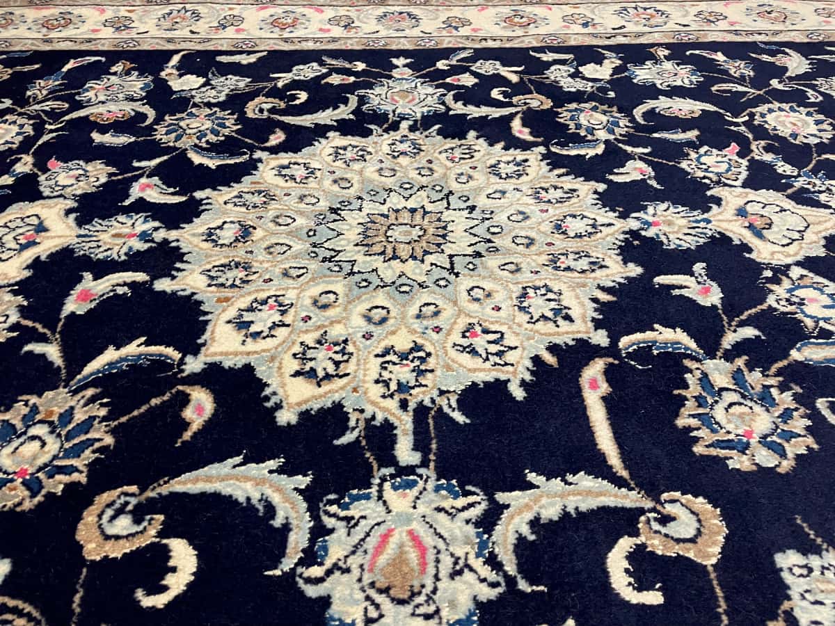 Persian rug of Nain style in dimensions 232 centimeters length by 168 centimeters width with mainly blue colors — Texture close-up