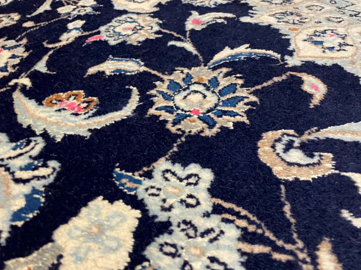 Persian rug of Nain style in dimensions 232 centimeters length by 168 centimeters width with mainly blue colors — Texture close-up