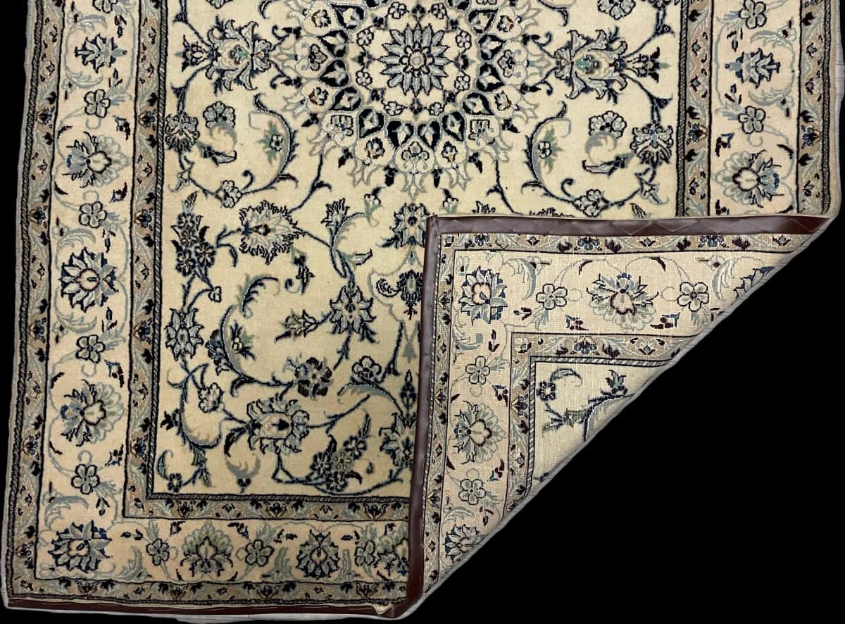 alfombra persa de estilo Nain en dimensiones 234 centímetros de largo por 165 centímetros de ancho con colores principalmente beige — Plegada