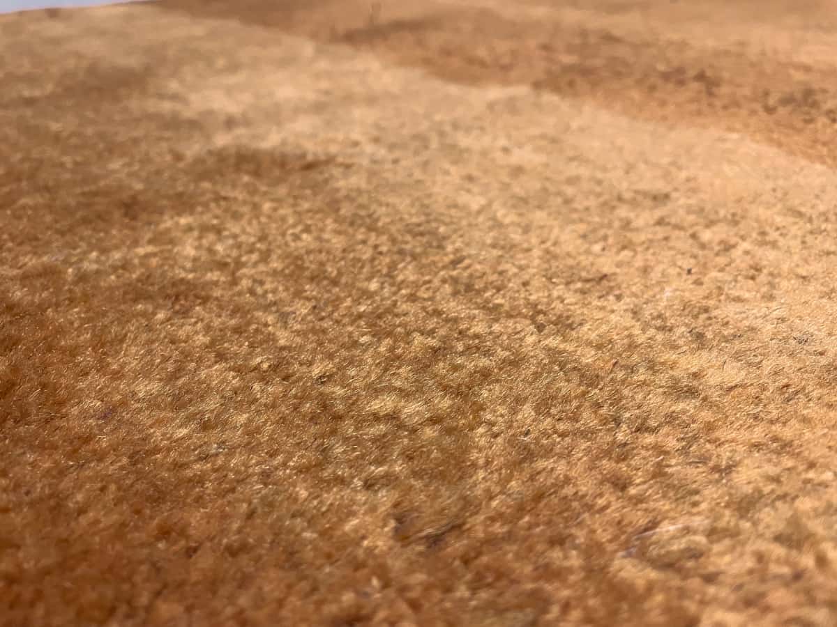 Persian rug of Gabbeh style in dimensions 150 centimeters length by 106 centimeters width with mainly orange colors — Texture close-up