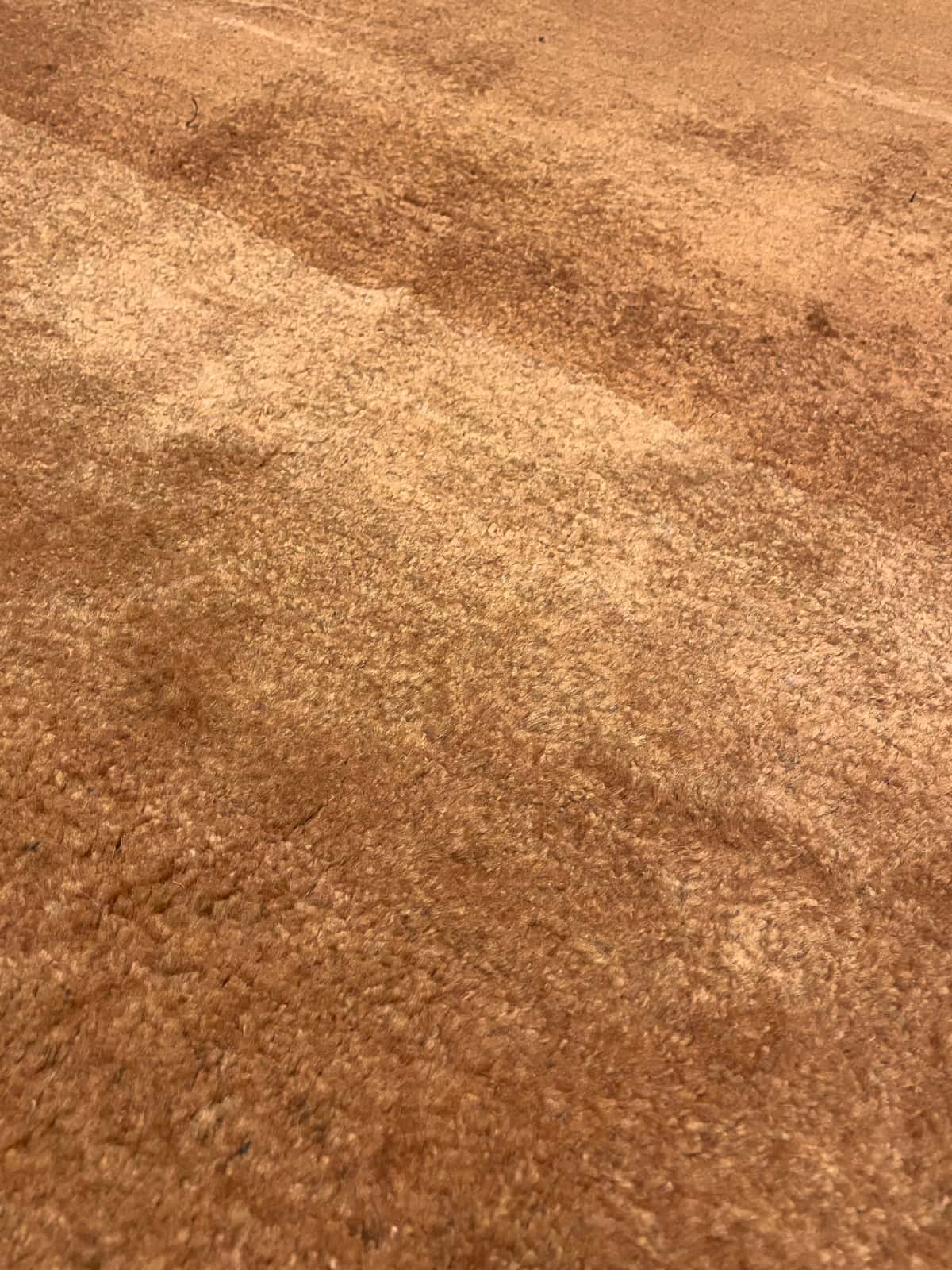Persian rug of Gabbeh style in dimensions 150 centimeters length by 106 centimeters width with mainly orange colors — Texture close-up