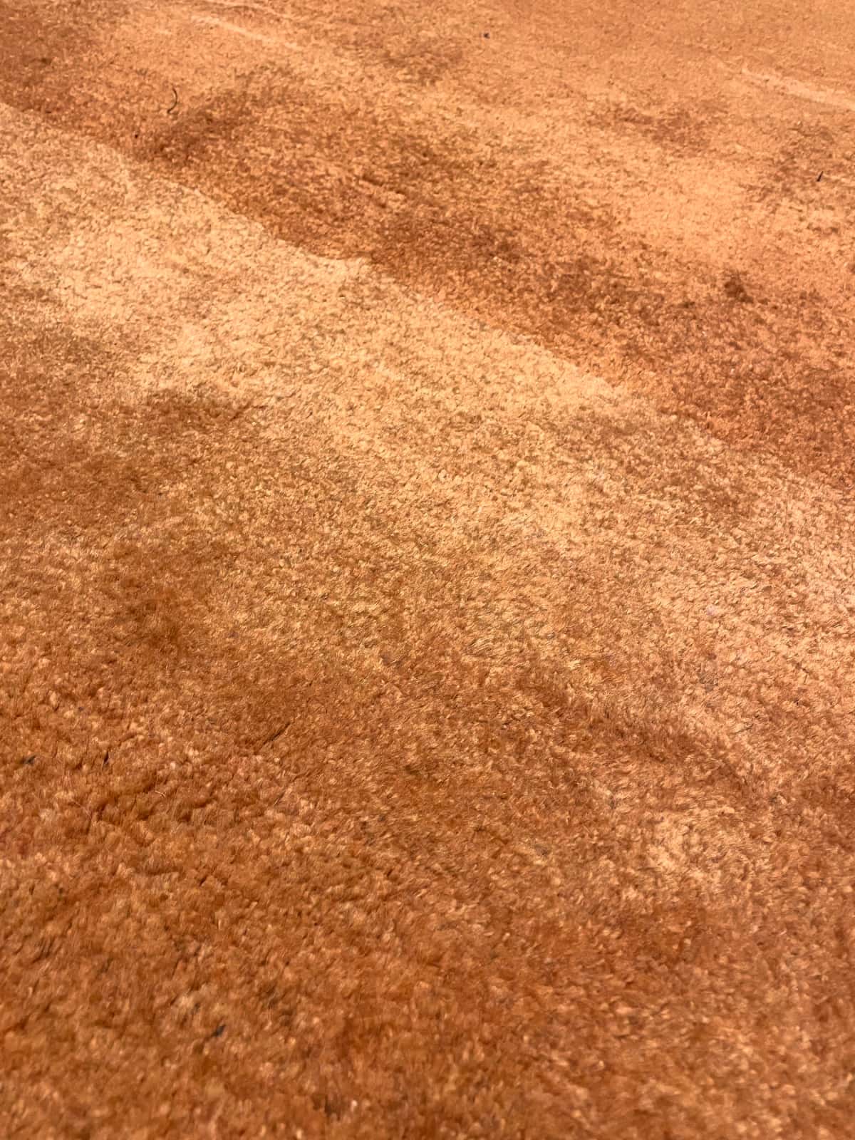 Persian rug of Gabbeh style in dimensions 150 centimeters length by 106 centimeters width with mainly orange colors — Texture close-up