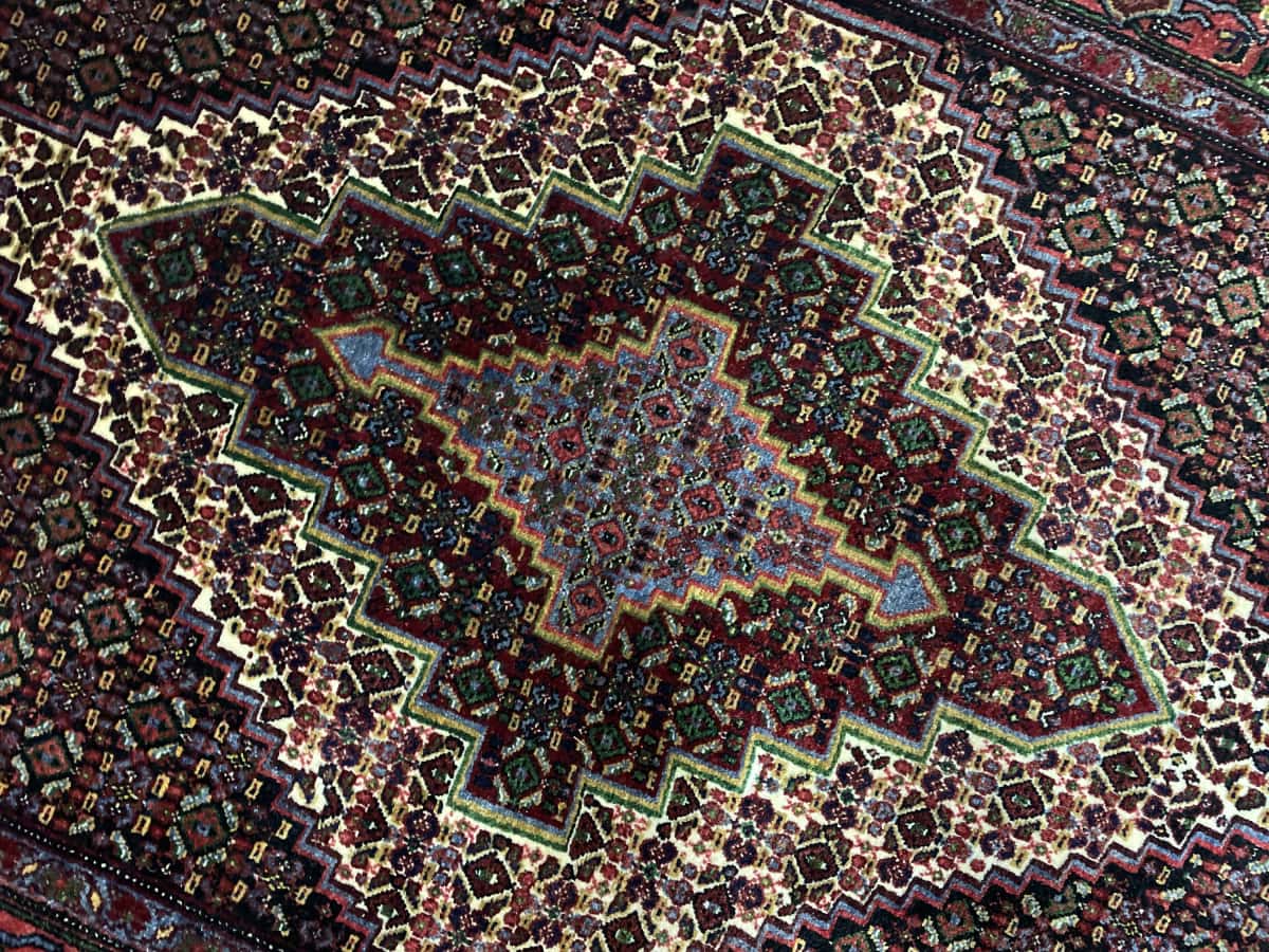 Persian rug of Sanandaj style in dimensions 182 centimeters length by 130 centimeters width with mainly colorful colors — Texture close-up