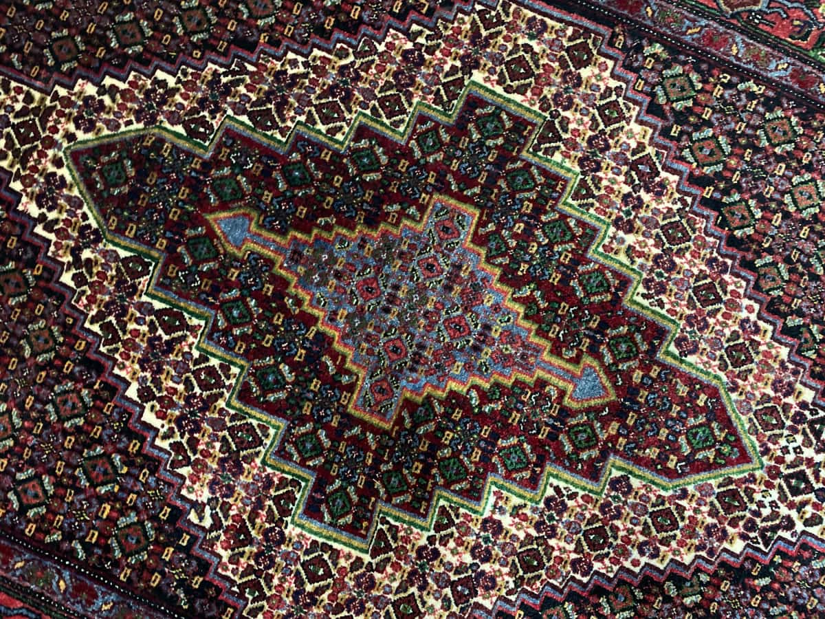 persischer Teppich im Sanandaj Stil in den Maßen 182 Zentimeter Länge mal 130 Zentimeter Breite mit überwiegend bunt Farben — Nahaufnahme der Textur