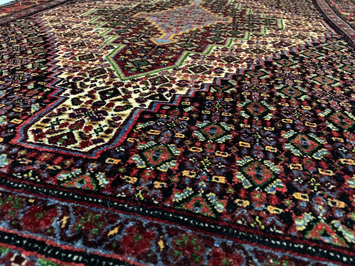 persischer Teppich im Sanandaj Stil in den Maßen 182 Zentimeter Länge mal 130 Zentimeter Breite mit überwiegend bunt Farben — Nahaufnahme der Textur