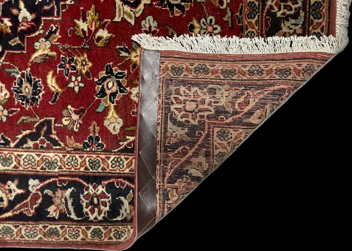 Persian rug of Kashan style in dimensions 143 centimeters length by 111 centimeters width with mainly red colors — Folded