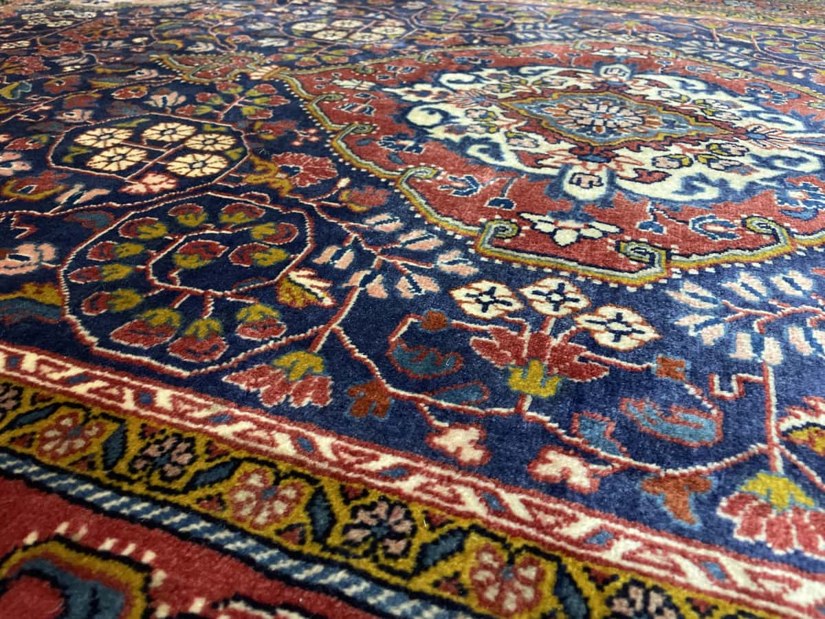 Persian rug of Malayer style in dimensions 209 centimeters length by 131 centimeters width with mainly red and blue colors — Texture close-up