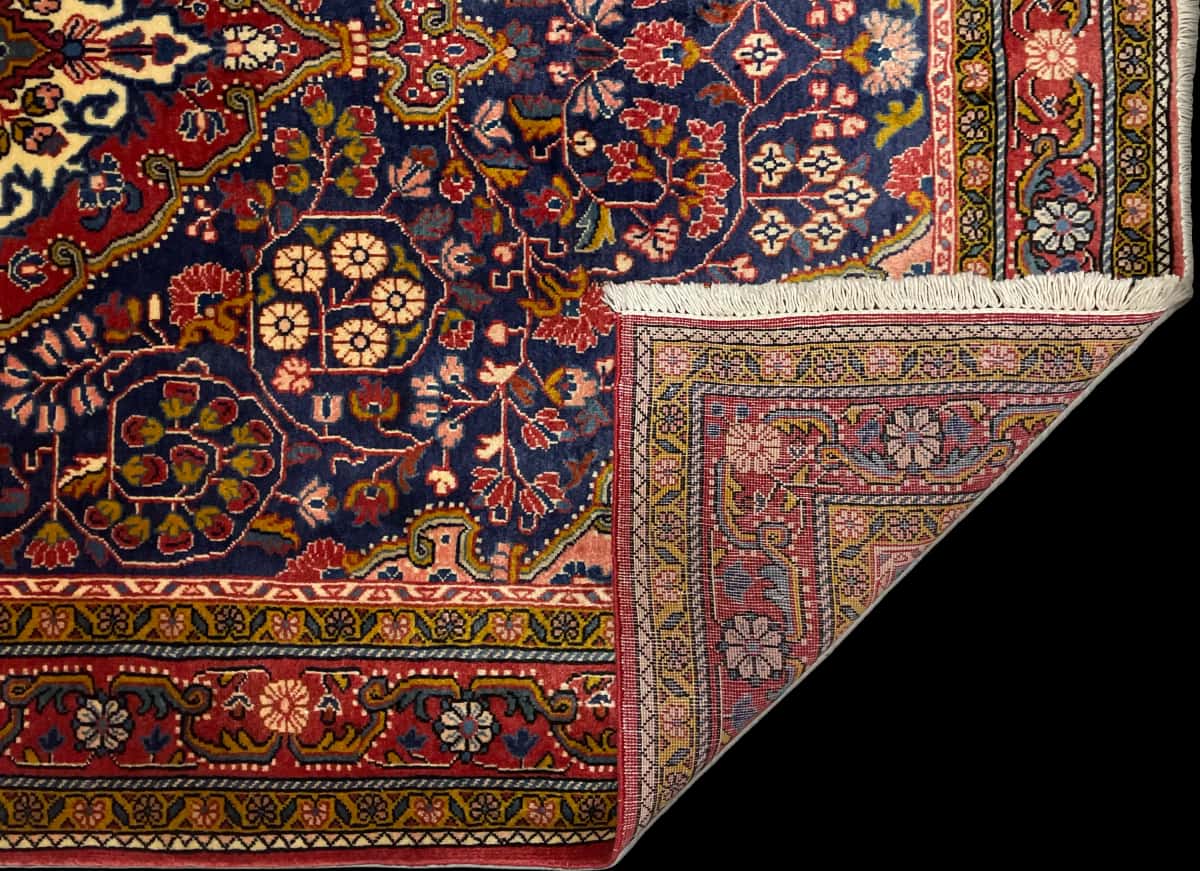 persischer Teppich im Malayer Stil in den Maßen 209 Zentimeter Länge mal 131 Zentimeter Breite mit überwiegend rot und blau Farben — Gefaltet