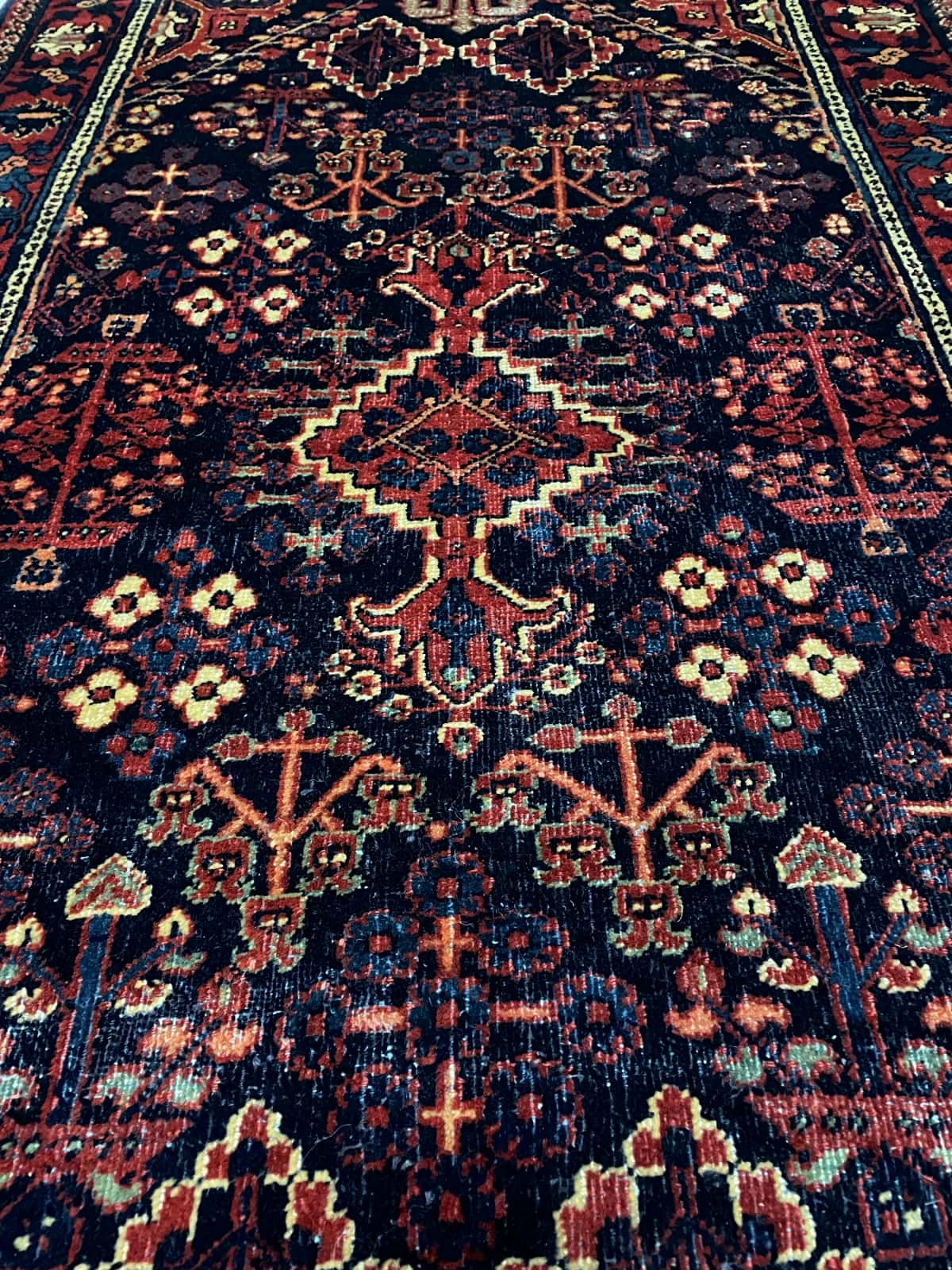 persischer Teppich im Kerman Stil in den Maßen 157 Zentimeter Länge mal 100 Zentimeter Breite mit überwiegend rot und blau Farben — Nahaufnahme der Textur