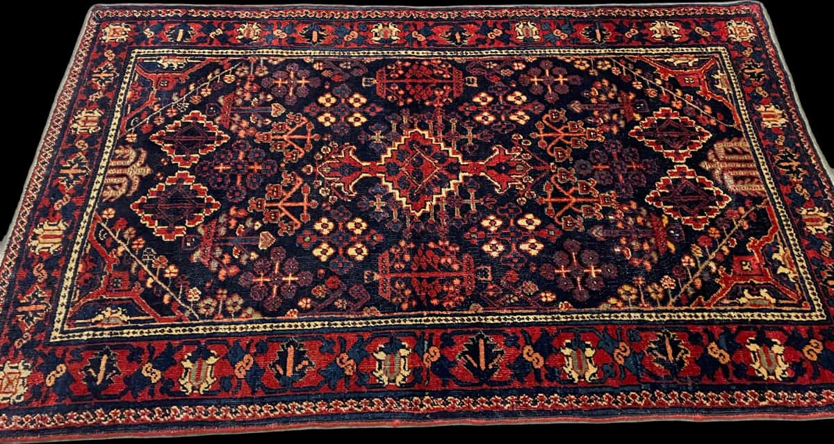 persischer Teppich im Kerman Stil in den Maßen 157 Zentimeter Länge mal 100 Zentimeter Breite mit überwiegend rot und blau Farben — Perspektive