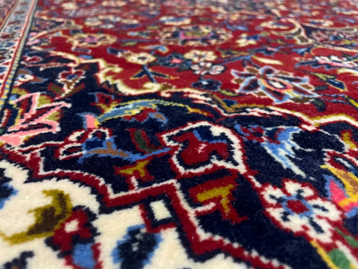 persischer Teppich im Kashan Stil in den Maßen 164 Zentimeter Länge mal 105 Zentimeter Breite mit überwiegend rot Farben — Nahaufnahme der Textur