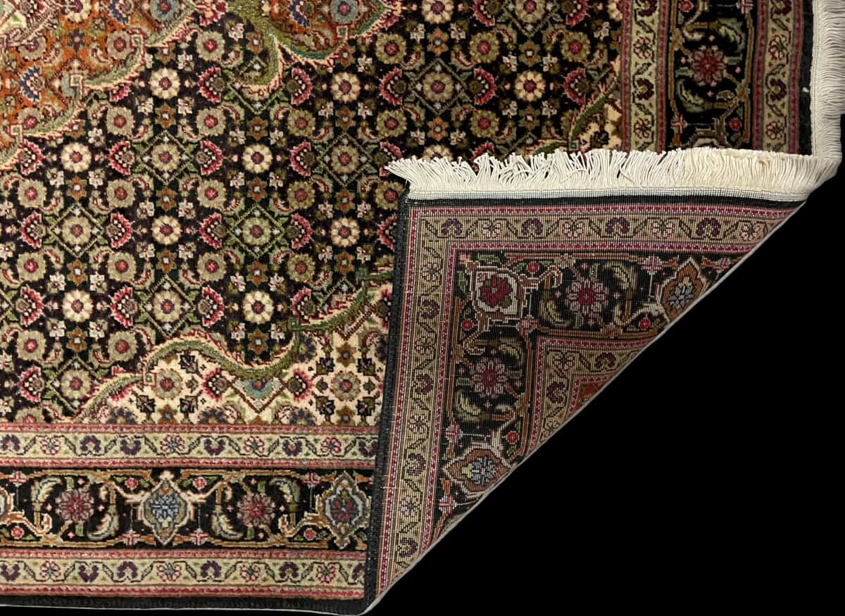 persischer Teppich im Khoy Stil in den Maßen 150 Zentimeter Länge mal 100 Zentimeter Breite mit überwiegend braun und schwarz Farben — Gefaltet