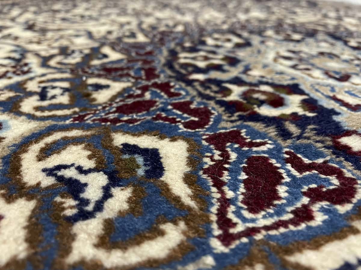 Persian rug in dimensions 202 centimeters length by 122 centimeters width with mainly blue and beige colors — Texture close-up