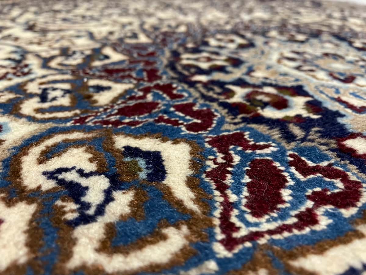 persischer Teppich im Nain Stil in den Maßen 202 Zentimeter Länge mal 122 Zentimeter Breite mit überwiegend blau und beige Farben — Nahaufnahme der Textur