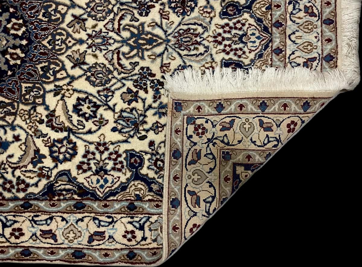 persischer Teppich im Nain Stil in den Maßen 202 Zentimeter Länge mal 122 Zentimeter Breite mit überwiegend blau und beige Farben — Gefaltet
