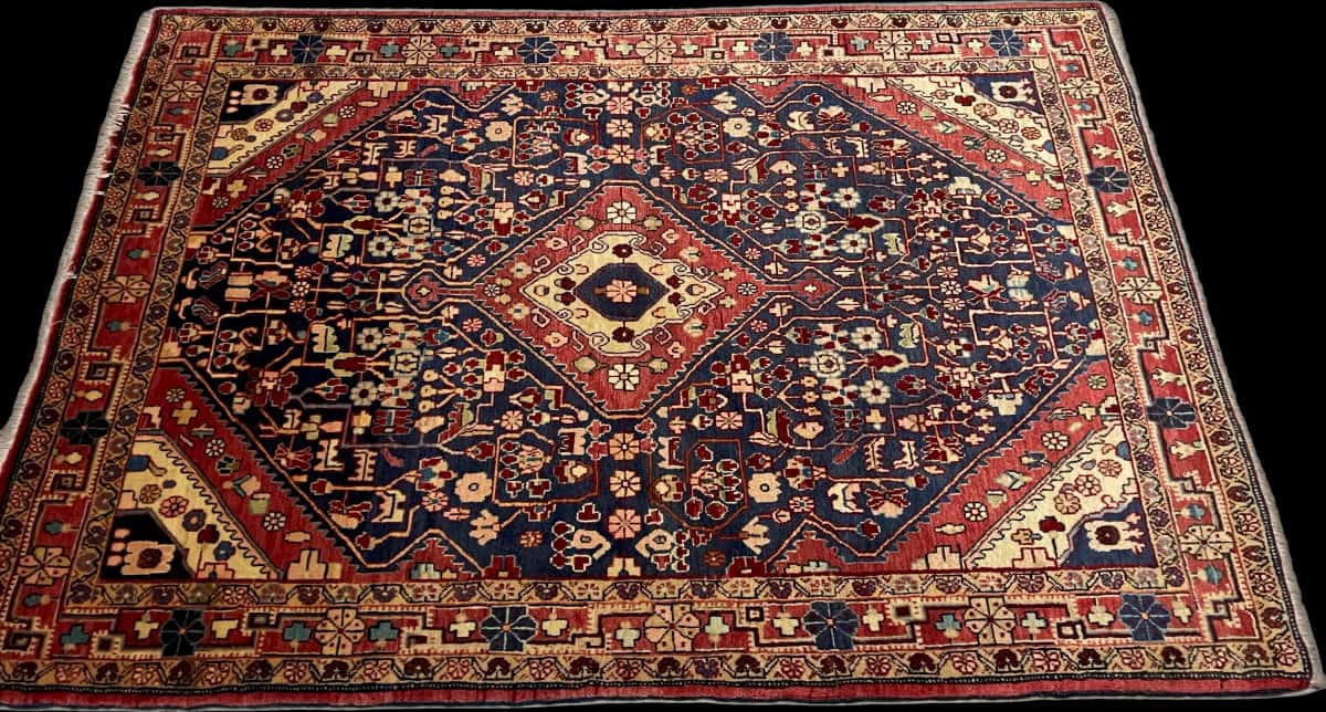 persischer Teppich im Malayer Stil in den Maßen 163 Zentimeter Länge mal 114 Zentimeter Breite mit überwiegend rot und blau Farben — Perspektive