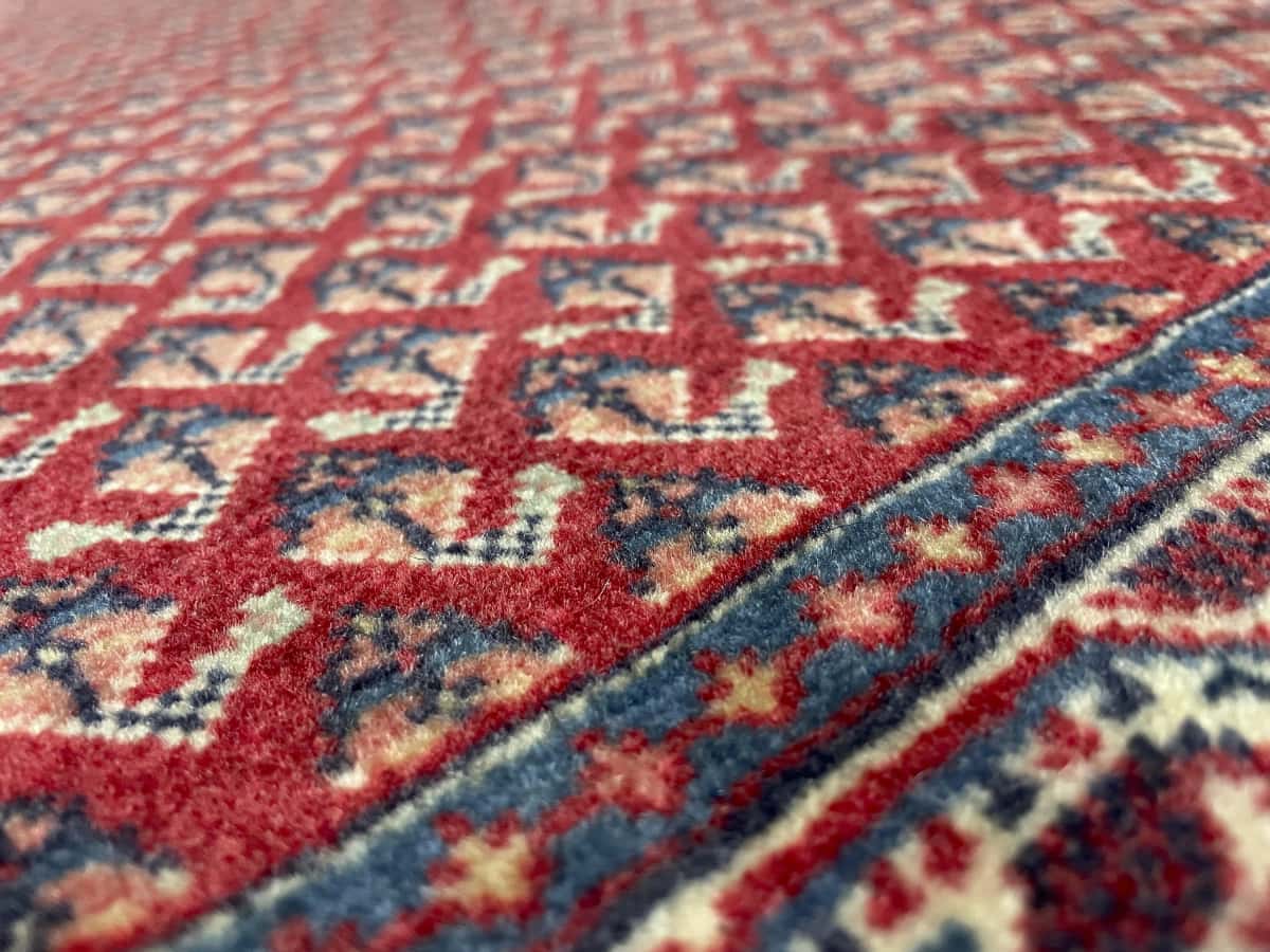 Persian rug of Arak style in dimensions 115 centimeters length by 67 centimeters width with mainly red and blue colors — Texture close-up