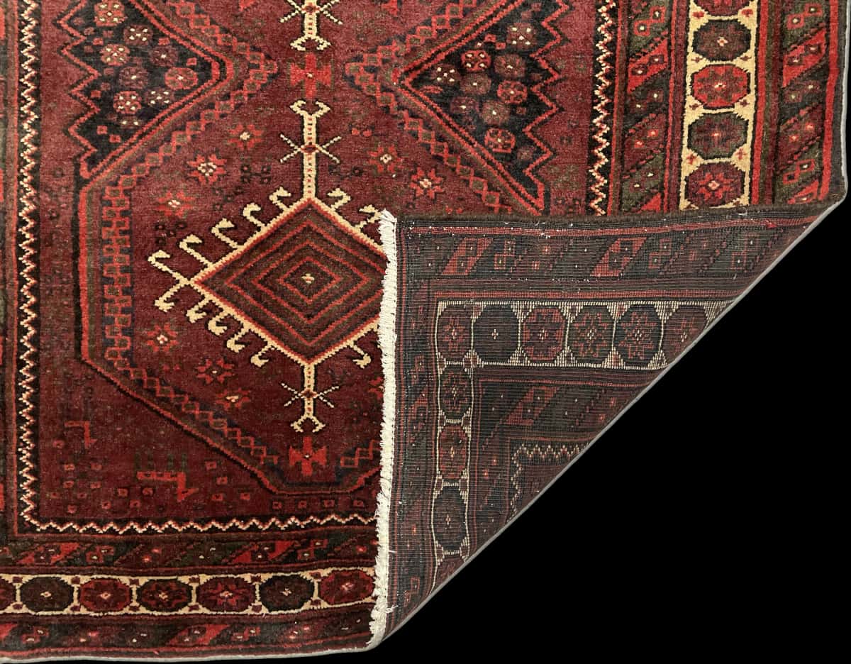 Persian rug of Baluch style in dimensions 205 centimeters length by 125 centimeters width with mainly red colors — Folded
