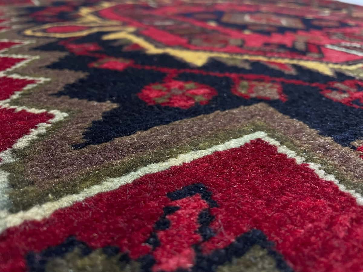 alfombra persa de estilo Nahavand en dimensiones 155 centímetros de largo por 115 centímetros de ancho con colores principalmente rojo — Primer plano de la textura