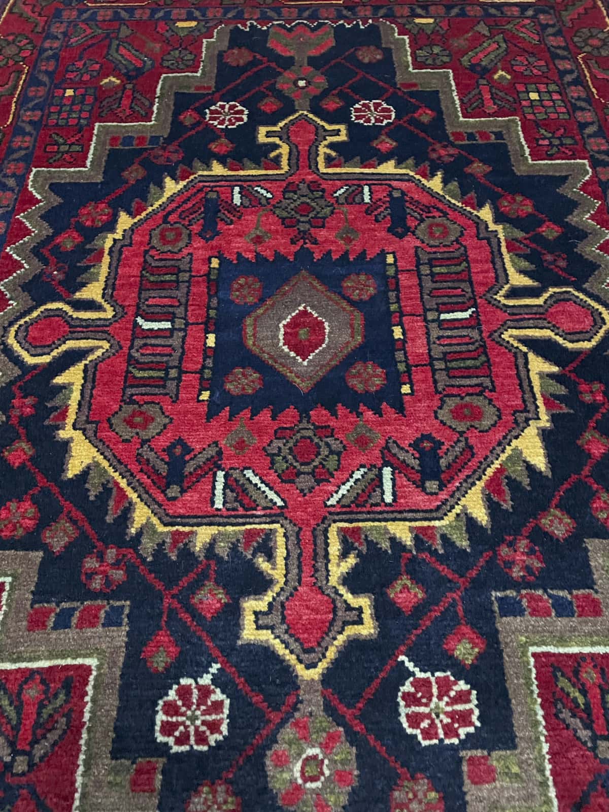 alfombra persa de estilo Nahavand en dimensiones 155 centímetros de largo por 115 centímetros de ancho con colores principalmente rojo — Perspectiva