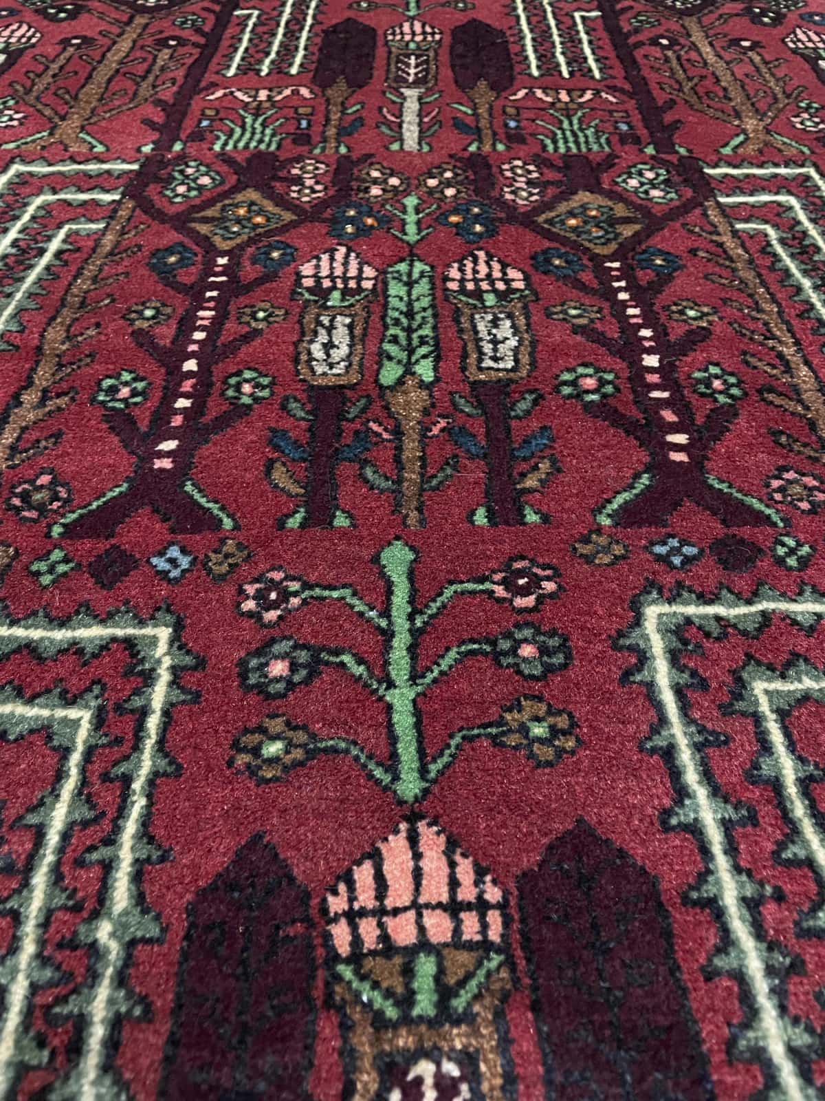 Persian rug of Nasrabad style in dimensions 162 centimeters length by 112 centimeters width with mainly red colors — Texture close-up