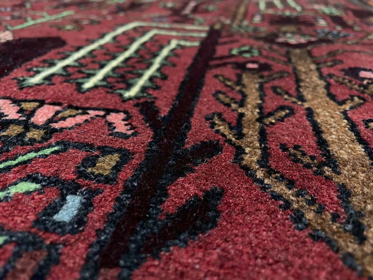 Persian rug of Nasrabad style in dimensions 162 centimeters length by 112 centimeters width with mainly red colors — Texture close-up
