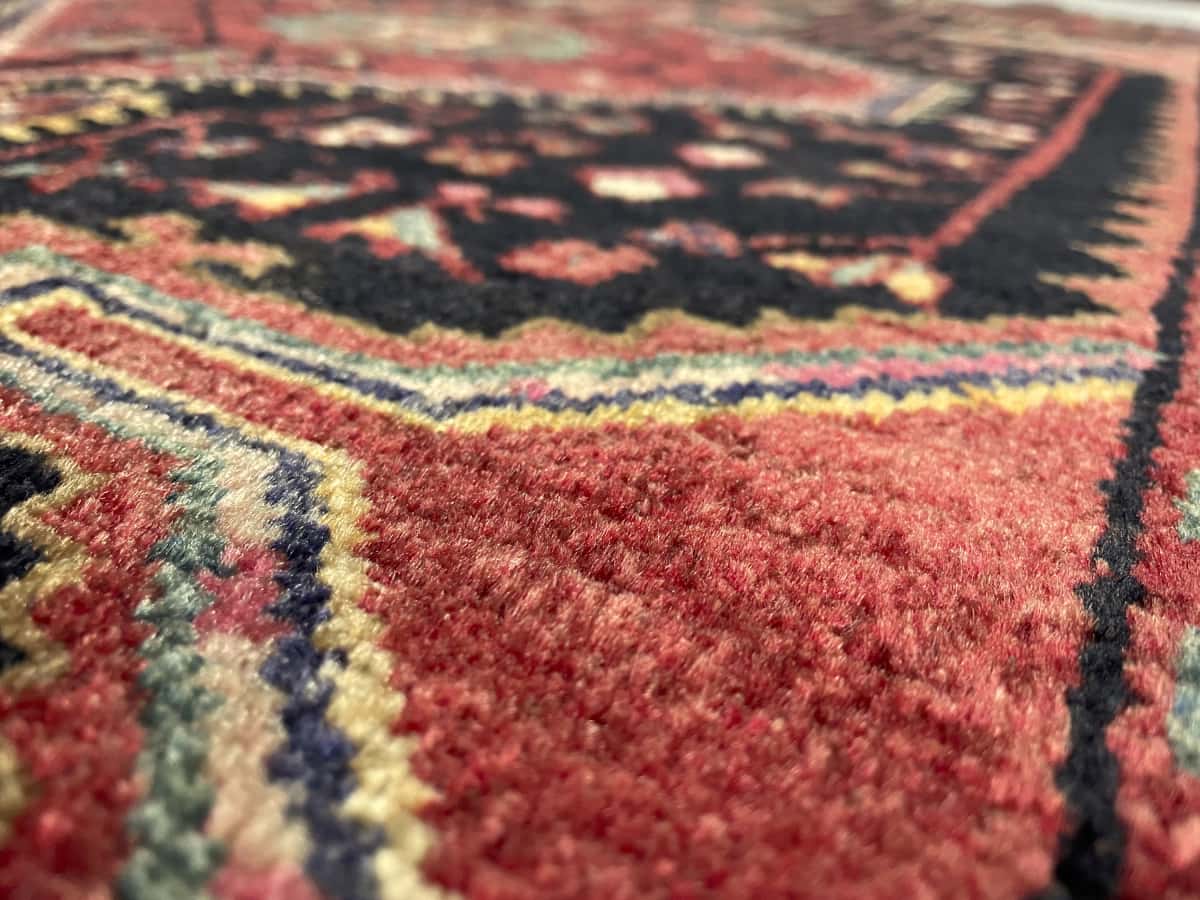 Persian rug of Hamadan style in dimensions 170 centimeters length by 103 centimeters width with mainly red and blue colors — Texture close-up