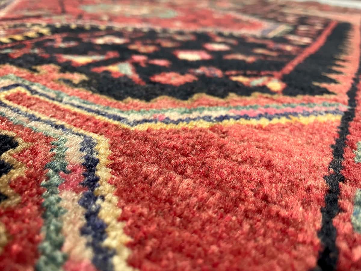 persischer Teppich im Hamadan Stil in den Maßen 170 Zentimeter Länge mal 103 Zentimeter Breite mit überwiegend rot und blau Farben — Nahaufnahme der Textur