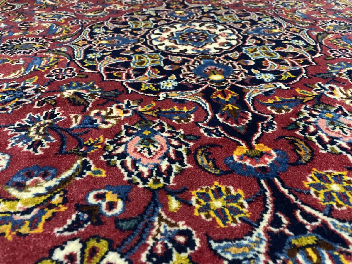 Persian rug of Kashan style in dimensions 184 centimeters length by 120 centimeters width with mainly red and blue colors — Texture close-up