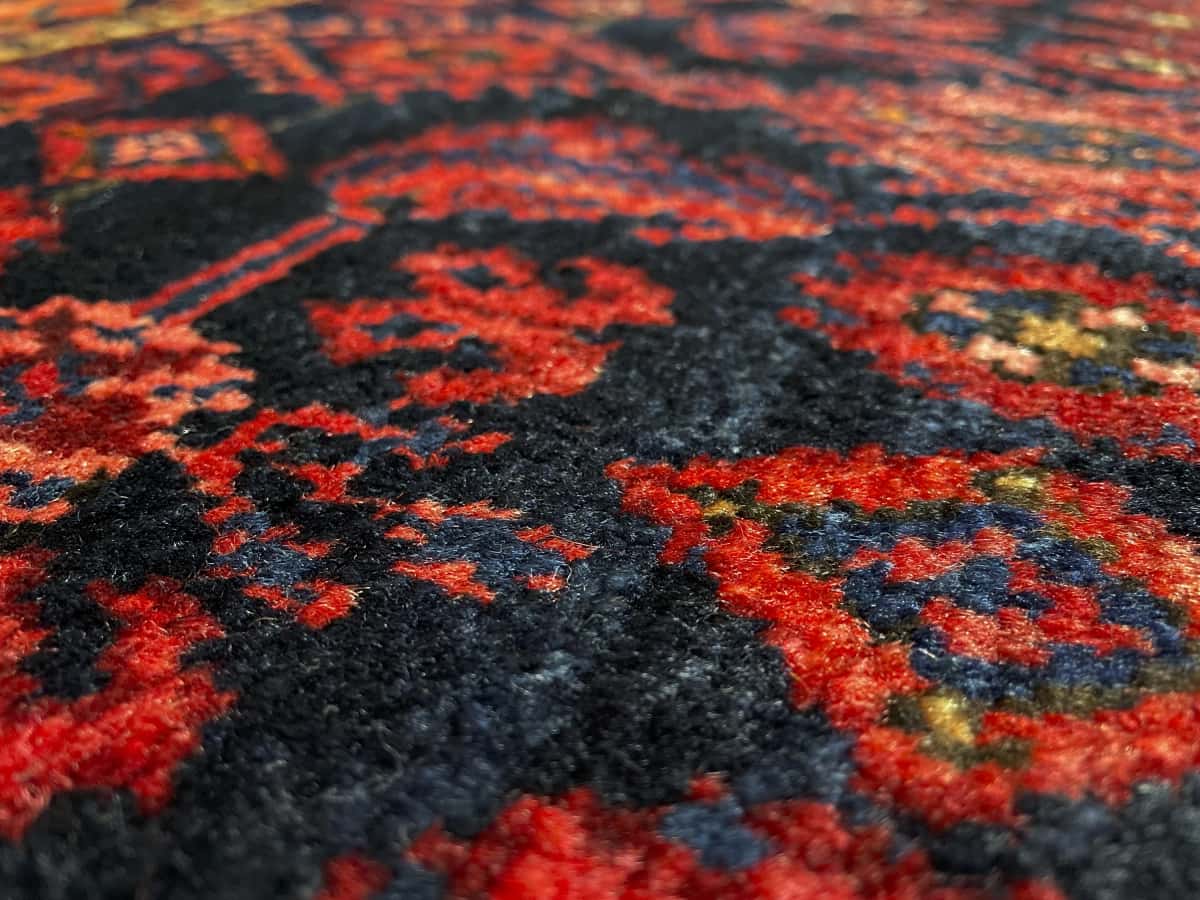 Persian rug of Turkoman style in dimensions 164 centimeters length by 106 centimeters width with mainly red and blue colors — Texture close-up