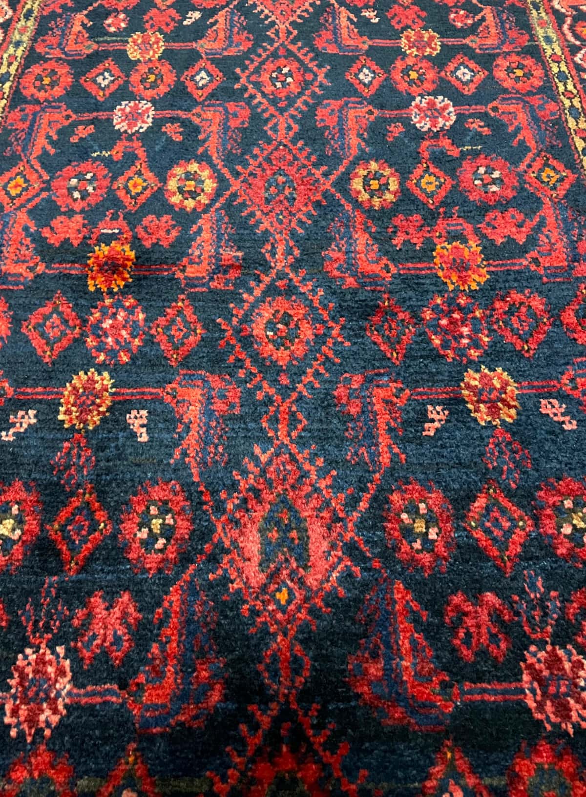 persischer Teppich im turkmenischer Stil in den Maßen 164 Zentimeter Länge mal 106 Zentimeter Breite mit überwiegend rot und blau Farben — Nahaufnahme der Textur