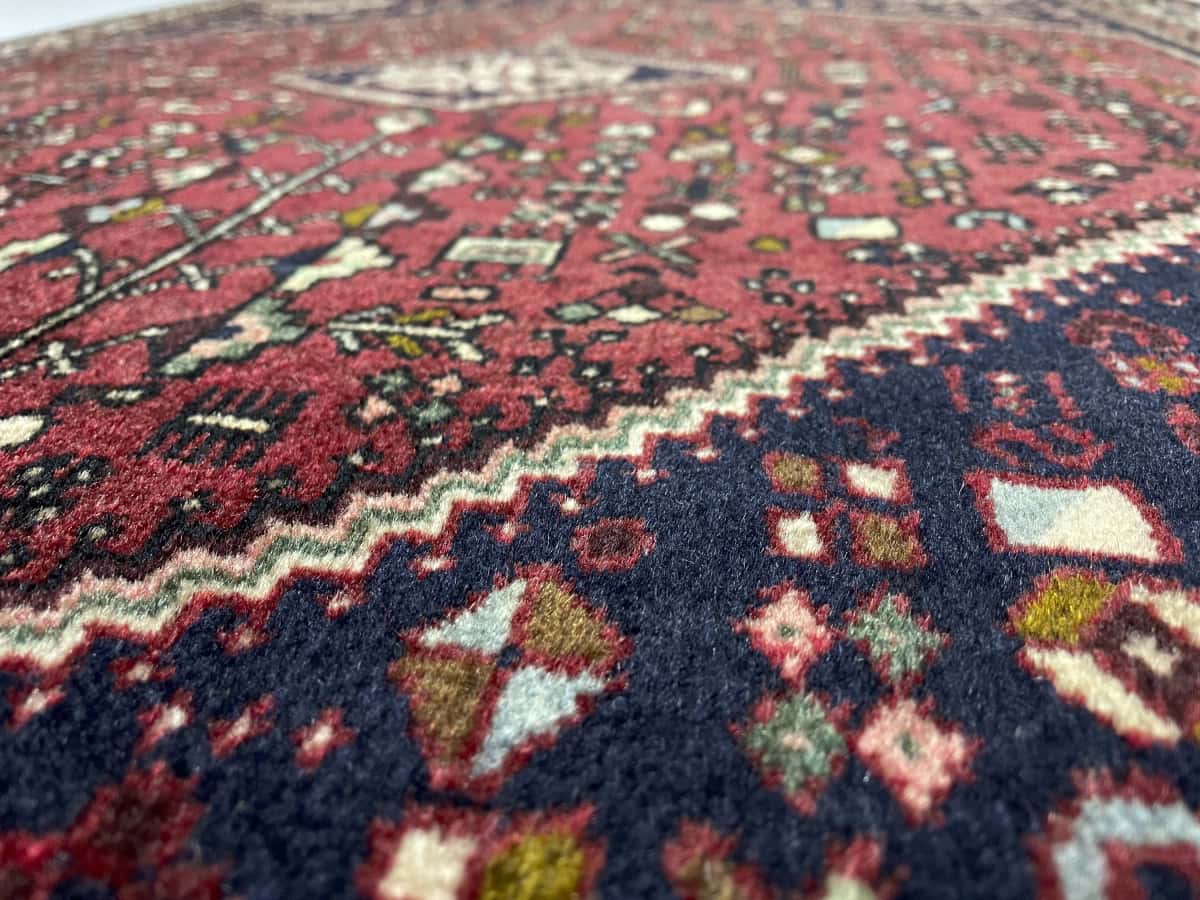Persian rug of Abadeh style in dimensions 152 centimeters length by 109 centimeters width with mainly red colors — Texture close-up