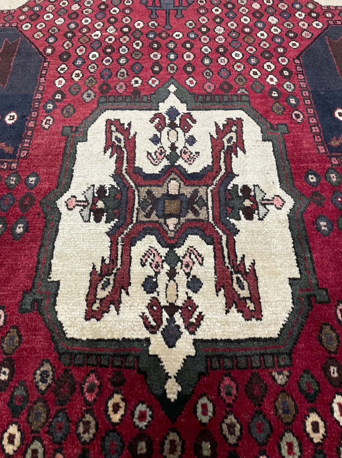 alfombra persa de estilo Shahr-e Babak en dimensiones 162 centímetros de largo por 107 centímetros de ancho con colores principalmente rojo — Primer plano de la textura