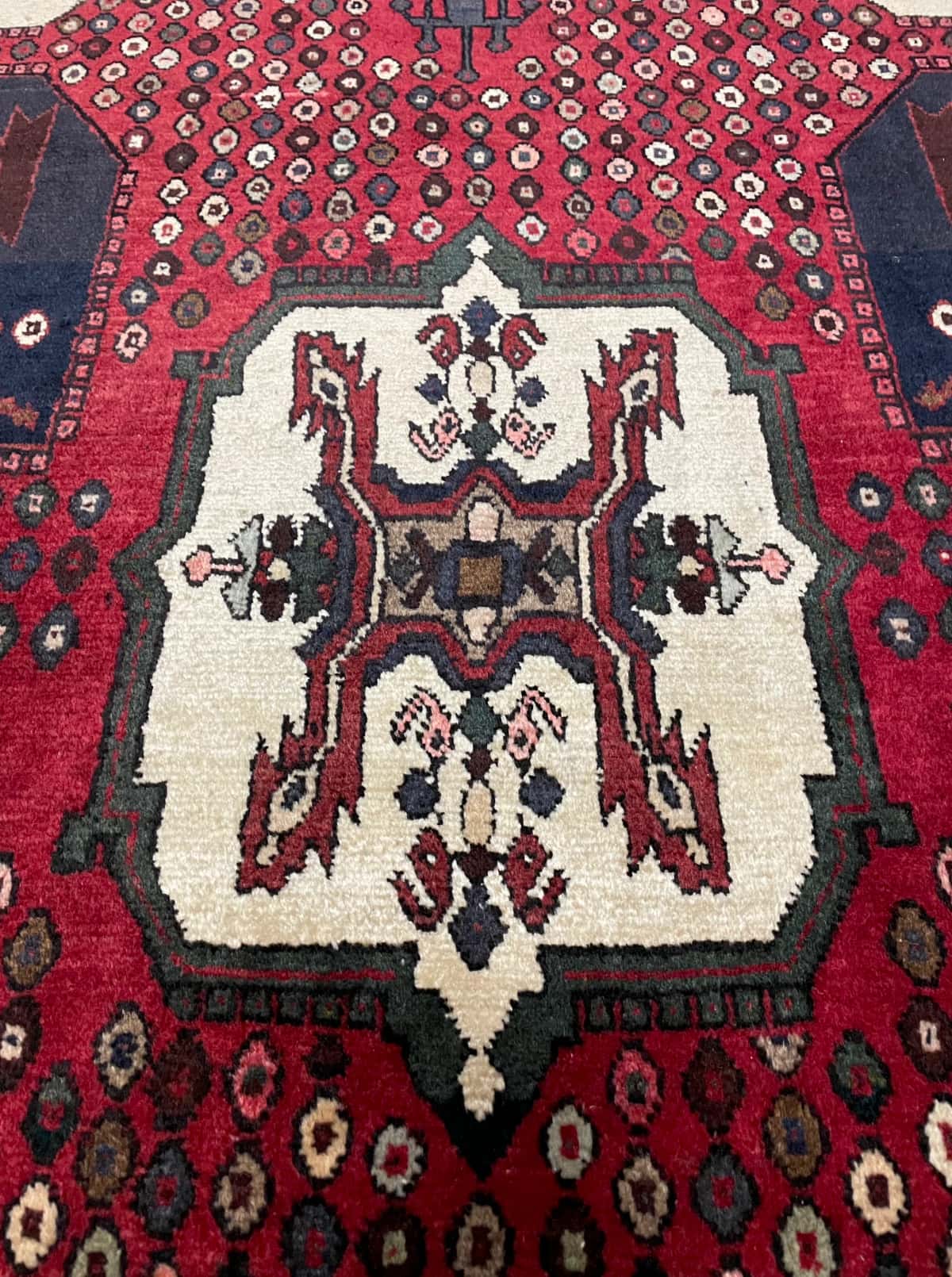 persischer Teppich im Shahr-e Babak Stil in den Maßen 162 Zentimeter Länge mal 107 Zentimeter Breite mit überwiegend rot Farben — Nahaufnahme der Textur