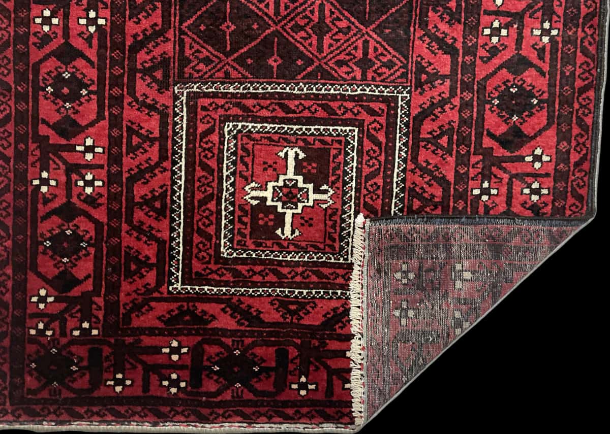 Persian rug of Baluch style in dimensions 208 centimeters length by 107 centimeters width with mainly red colors — Folded