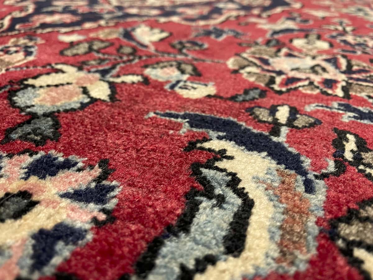 alfombra persa de estilo Aran va Bidgol en dimensiones 160 centímetros de largo por 100 centímetros de ancho con colores principalmente rojo — Primer plano de la textura