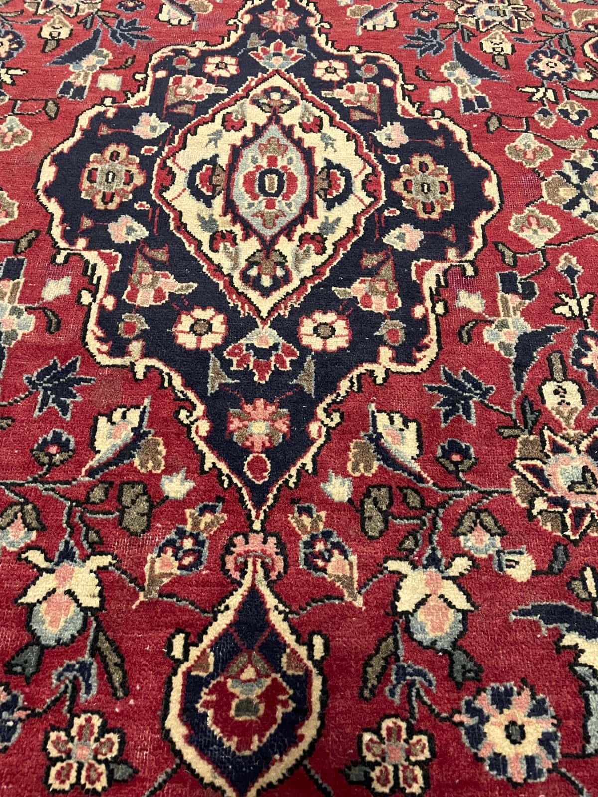 alfombra persa de estilo Aran va Bidgol en dimensiones 160 centímetros de largo por 100 centímetros de ancho con colores principalmente rojo — Primer plano de la textura