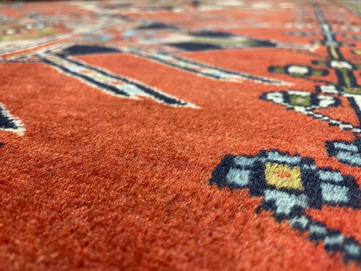 persischer Teppich im Quchan Stil in den Maßen 170 Zentimeter Länge mal 130 Zentimeter Breite mit überwiegend orange Farben — Nahaufnahme der Textur